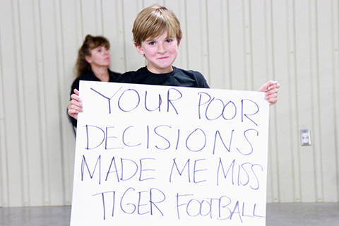 A student laments missing Tiger football’s opening playoff game for the TCEQ permit meeting. (photo by Samantha Smith)