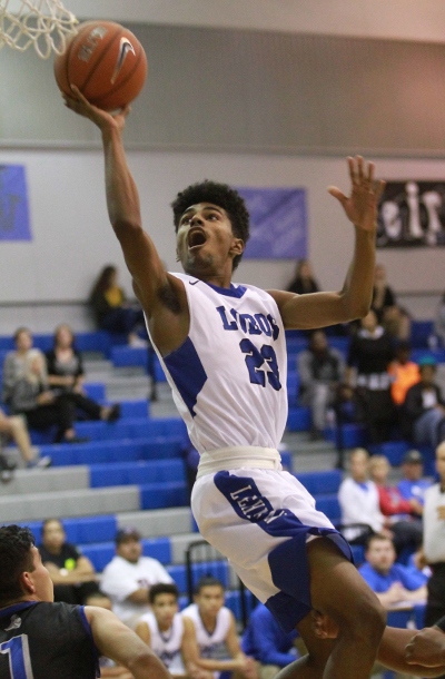 Lehman Lobo guard Tracey Malrey contorts his body as he attacks the rim during Monday's nondistrict tilt at the Lobo Den in Kyle. (photo by Moses Leos III)