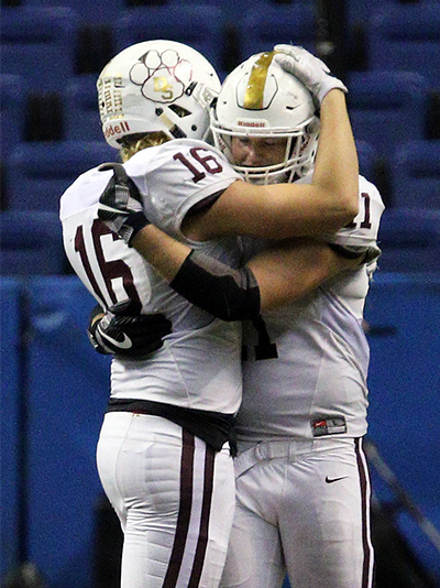 Below: Dripping Springs’ seniors Cullen Young (16) and McKenly O’Neal hug after a bitter 51-28 loss to Richmond Foster in the Class 5A Division I quarterfinal at the Alamodome last Saturday.  (photo by Wayland D. Clark)