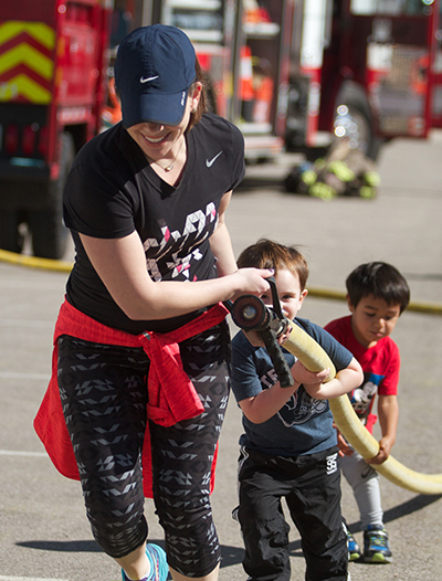 Teamwork made the dream work Saturday as Dripping Springs resident Merideth McDonald (left) received help from Madden, her son, and Mateo Padron during a fire hose pulling exercise at Dripping Springs Ranch Park. (photo by Moses Leos III)
