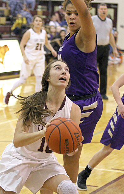 Dripping Springs’ senior Nicole Nading looks for a shot under the basket and the outstretched arm of Marble Falls’ Meghan Owens. Getting shots off and rebounding was a tall order for the Tigers, who were at a height disadvantage against Marble Falls, but one the Lady Tigers almost overcame. (photo by Wayland D. Clark)