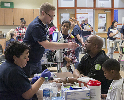 Volunteers at the 2015 Medical Mission at Home in Hutto checks vitals of eventgoers.  (photo courtesy of Seton Hays)
