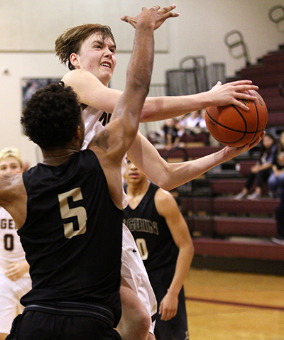 Dripping Springs’ Nick Breen makes an awkward shot at the basket for two points as he goes around Seguin’s Jaren Sayles (5) defending on the play. Breen finished with 10 points. (photo by Wayland D. Clark, wfotos.com()