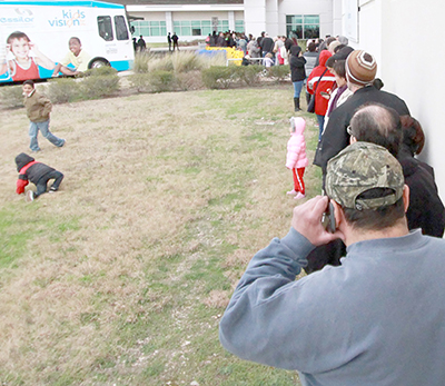 Approximately 100 people patiently wait in line near the entrance of Seton Medical Center Hays for Ascension’s Medical Mission at Home to open Saturday morning. People were in line for as long as three hours for the event, which offered free healthcare services for area residents. (photo by Moses Leos III)