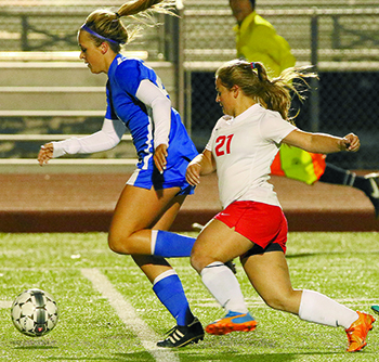 Hays Rebel senior Maya Hood (21) eyes a chance to regain possession of the soccer ball during Friday’s district match at Shelton Stadium. (photo by Tracy Stirman)
