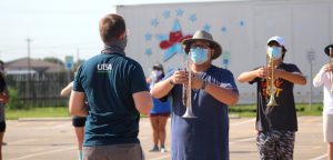 The band plays on: Hays High School Band, masks at ready, hits the practice field